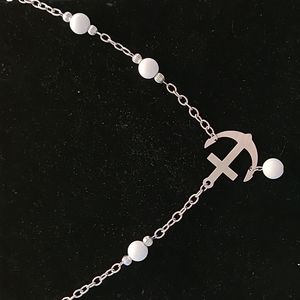 Costume Anchor Necklace with Silver Tone Beads positioned next to White Bead